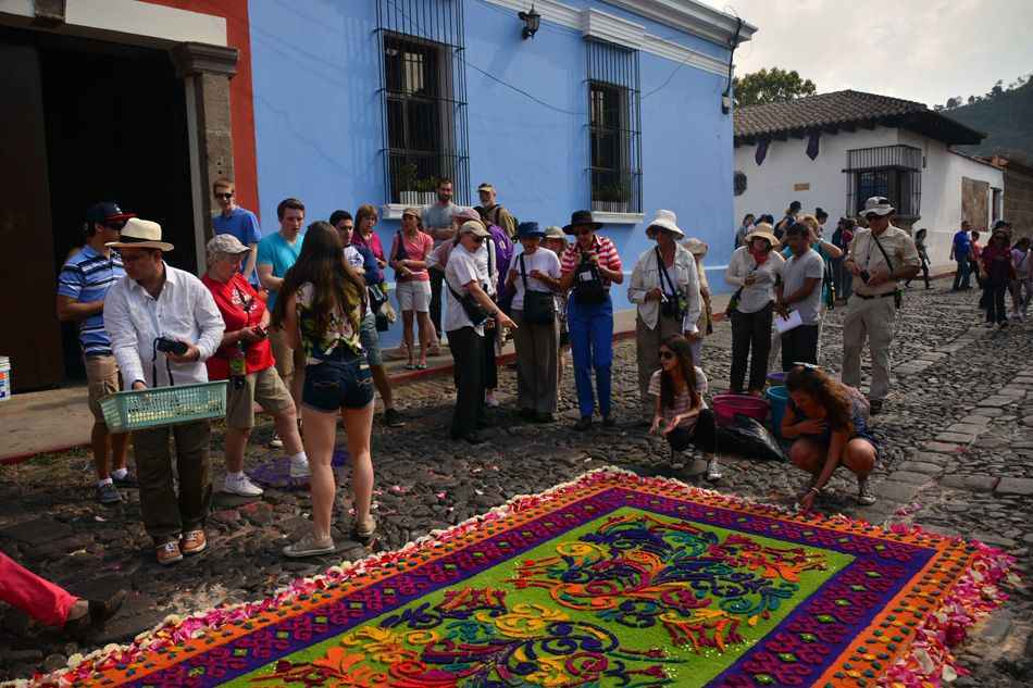 A group watching Easter carpets being made