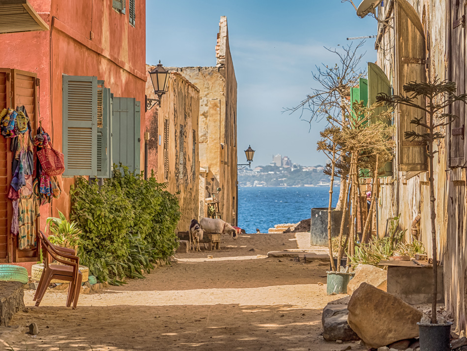 Goree, Senegal- February 2, 2019: Daily life, sandy road on the Goree island  and view of the city of Dakar Gorée. Dakar, Senegal. Africa.