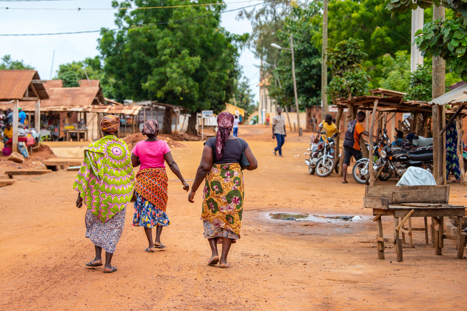 Togoville village in Togo. Women walking in African outfits in t